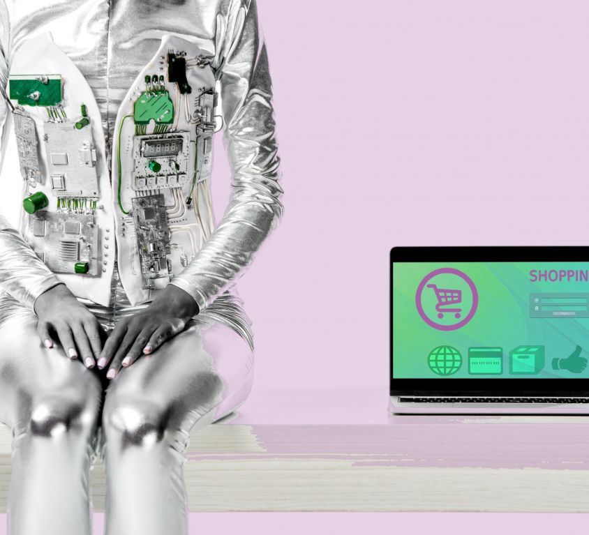 cropped-image-of-robot-sitting-on-table-near-lapto